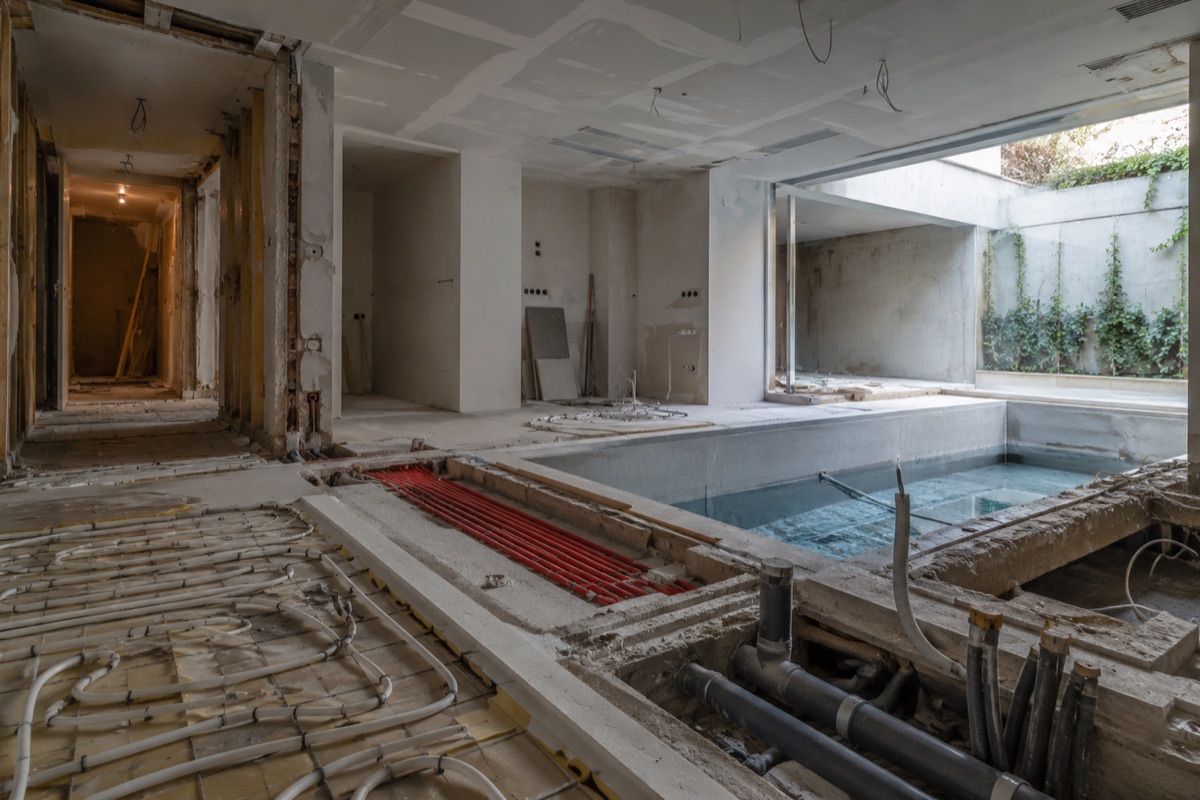 Vista de la piscina interior en obra, con su relación con el patio inglés y las instalaciones vistas